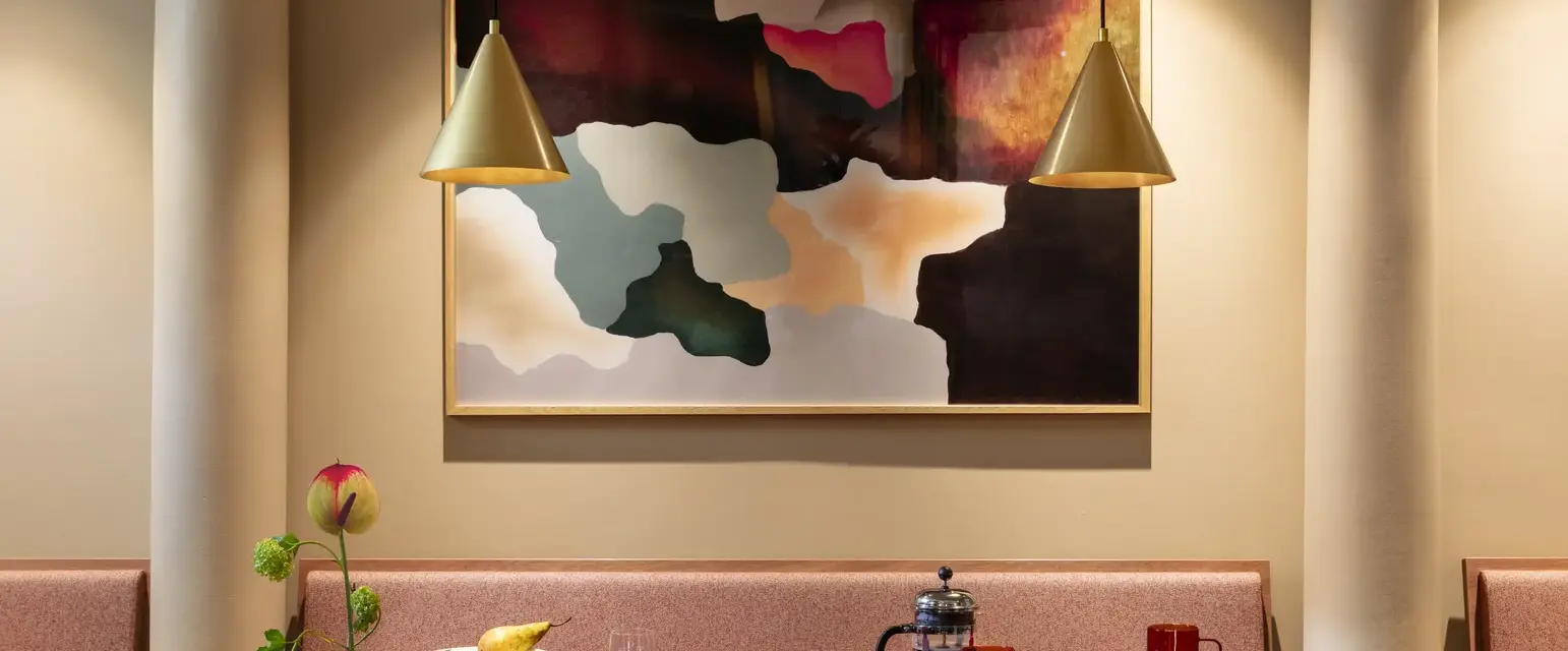 a table with chairs and a painting on the wall