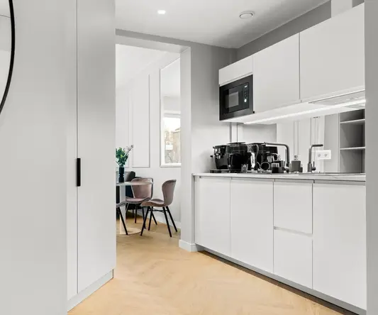 a kitchen with white cabinets and a wood floor