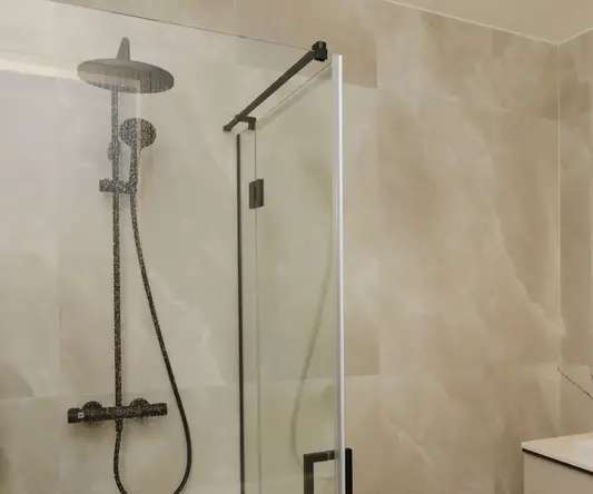 a shower with a glass door and a sink