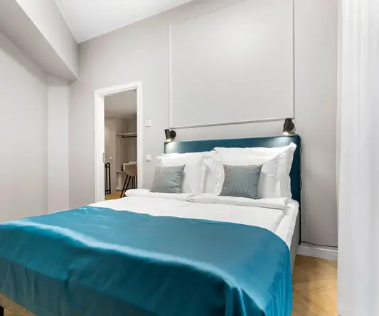 a bed with blue blanket and pillows