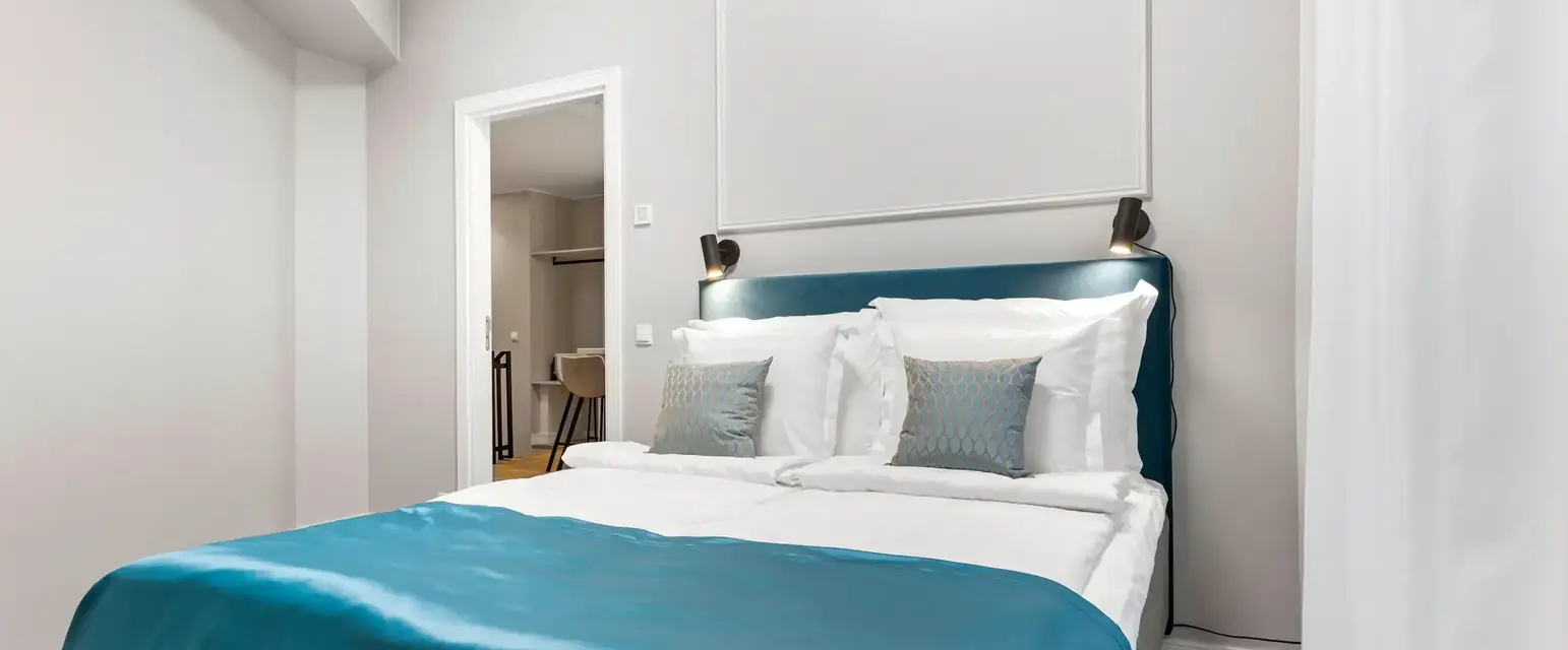 a bed with blue blanket and pillows