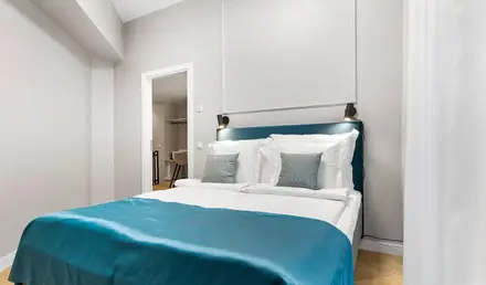 a bed with blue blanket and pillows