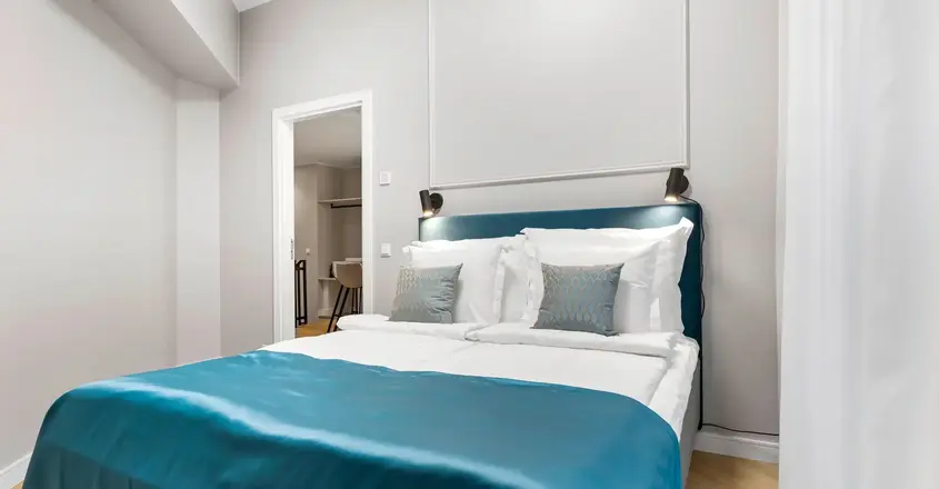 a bed with blue blanket and pillows