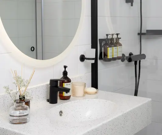 a bathroom with a round mirror and a shower