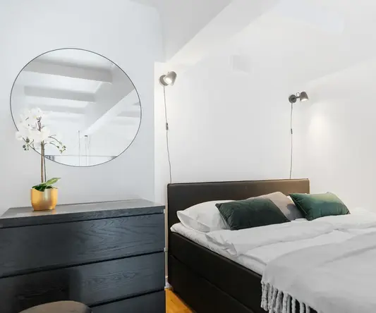 a bed with pillows and a dresser in a room