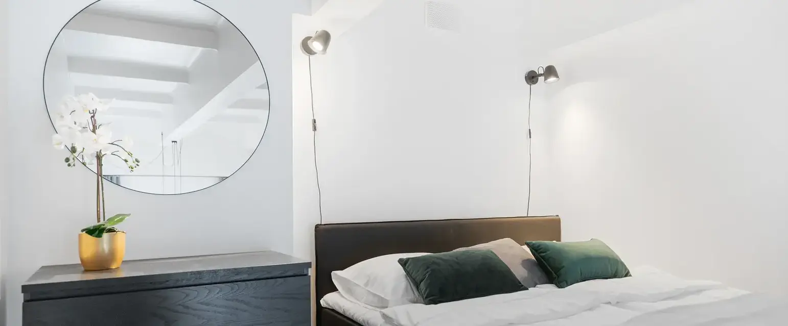 a bed with pillows and a dresser in a room