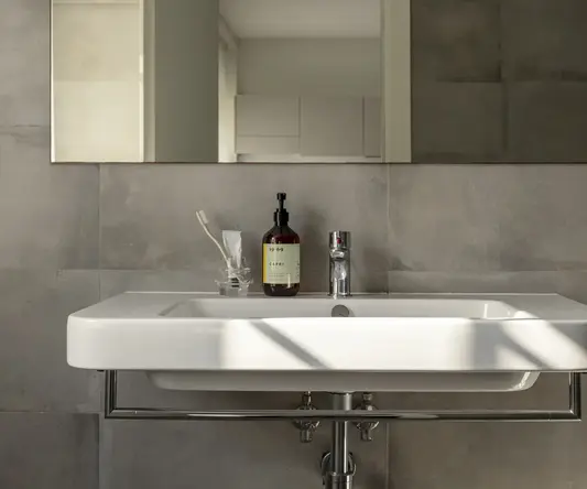 a bathroom sink with a bottle of soap on the top