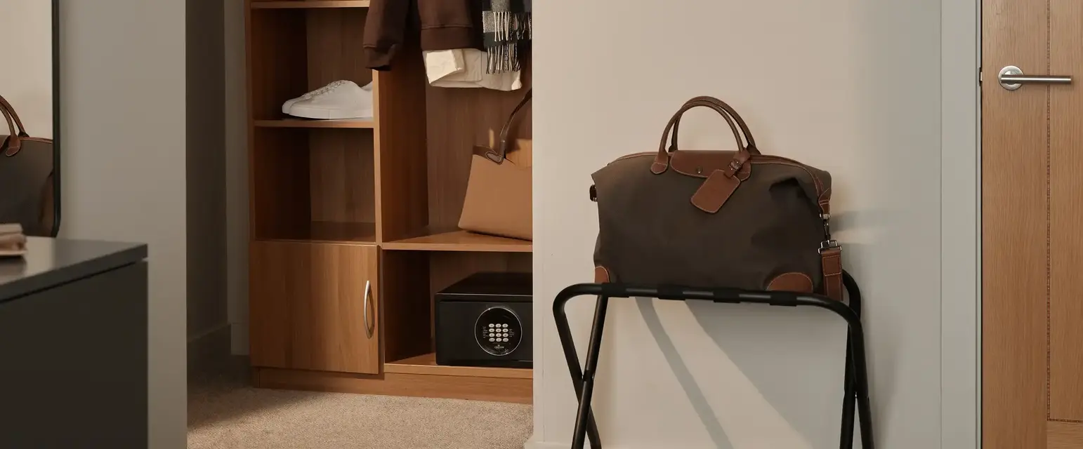 a closet with a bag and clothes on it