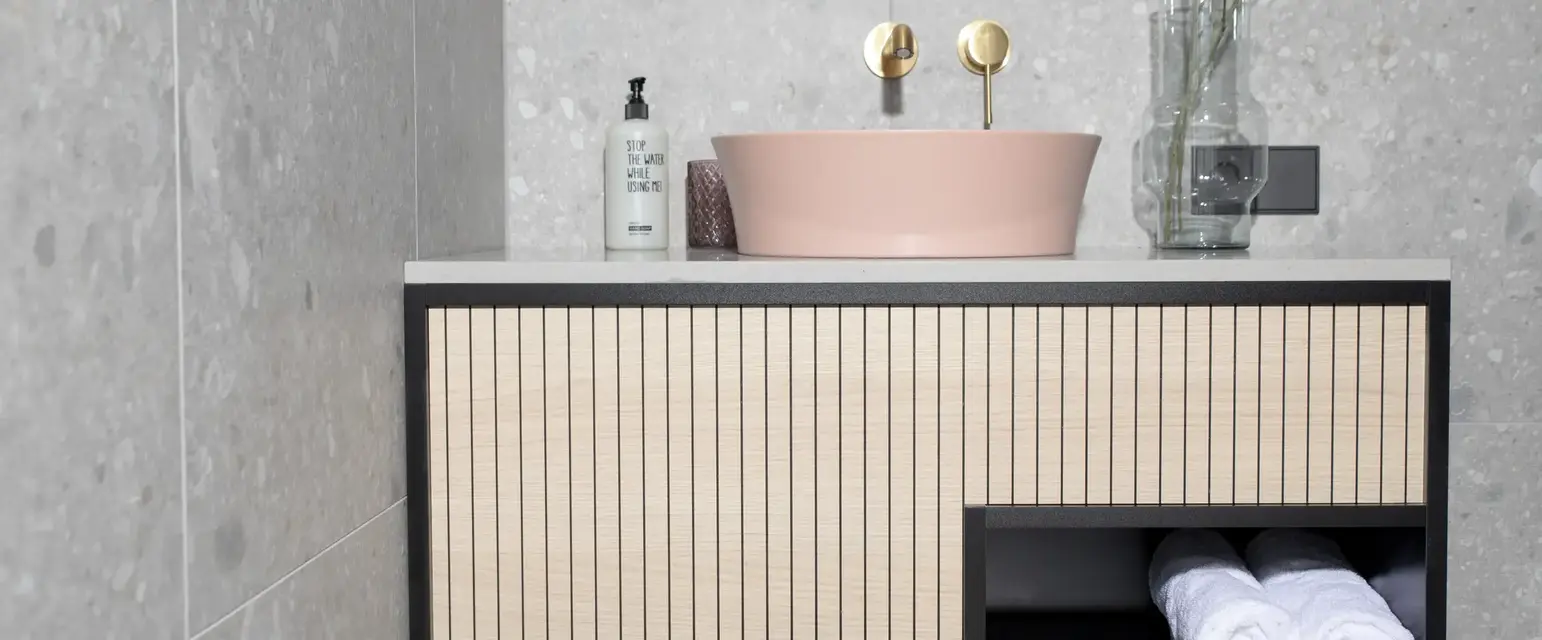 a bathroom sink with a round mirror and a white towel