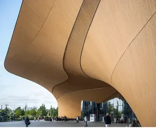 a large curved building with people walking around