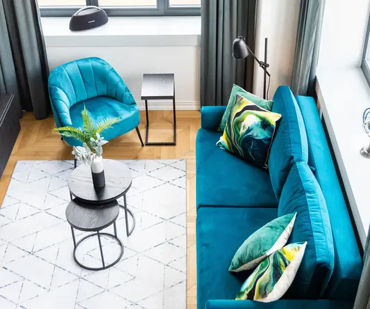 a living room with a blue couch and blue chairs
