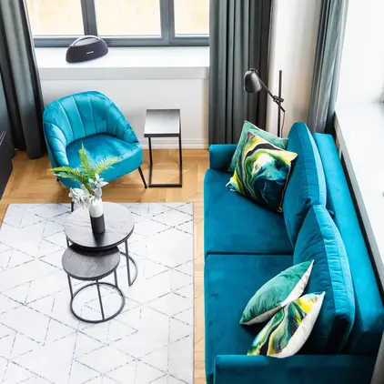 a living room with a blue couch and blue chairs