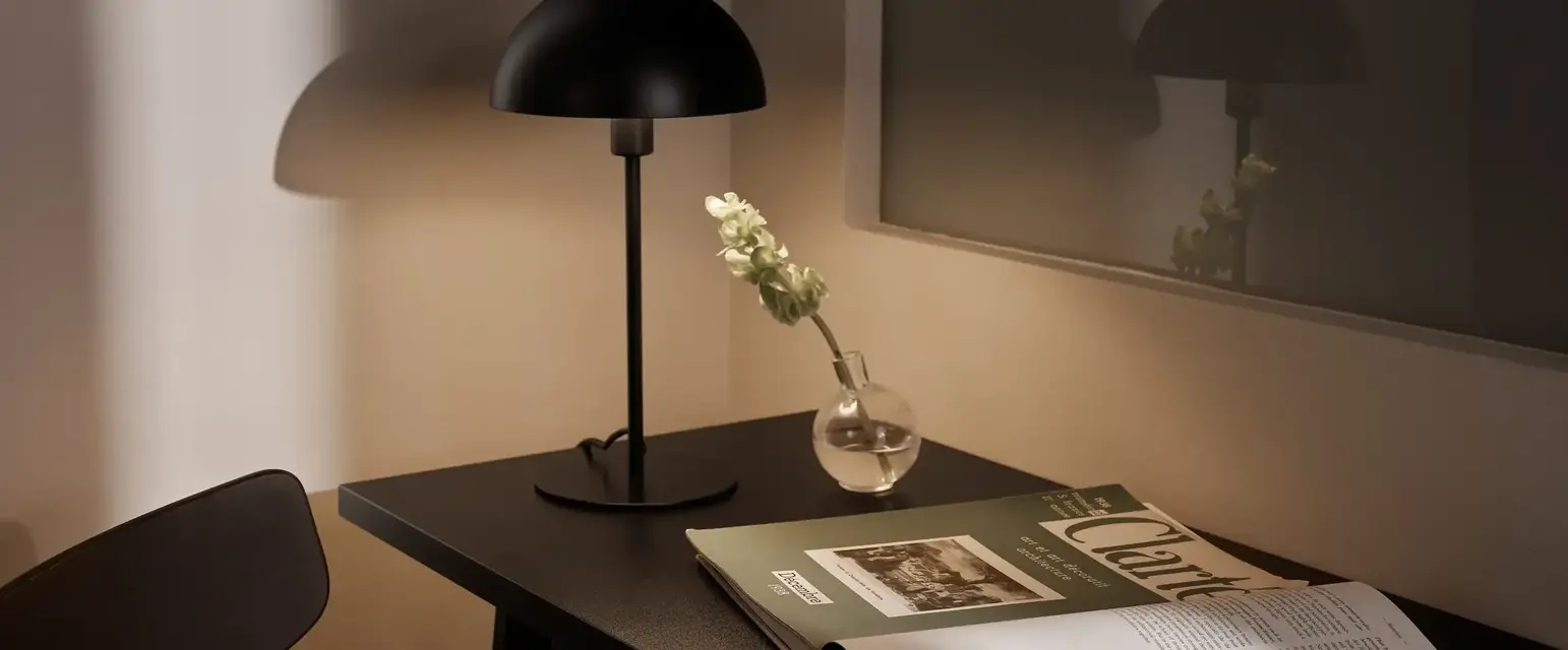 a table with a lamp and a vase on it