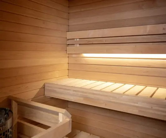 a wooden sauna with shelves and a bucket