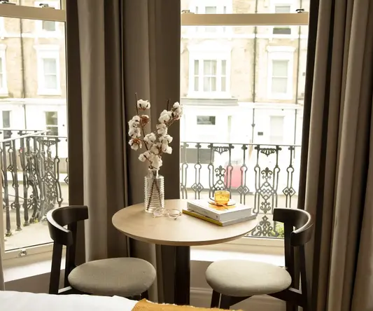 a table with a vase of cotton on it and a book on it