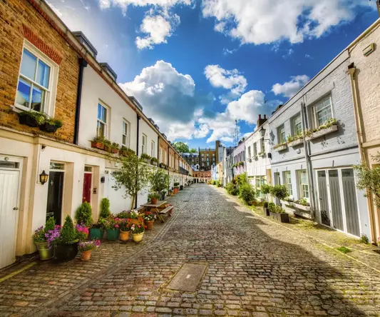 a street with brick buildings and plants on the side