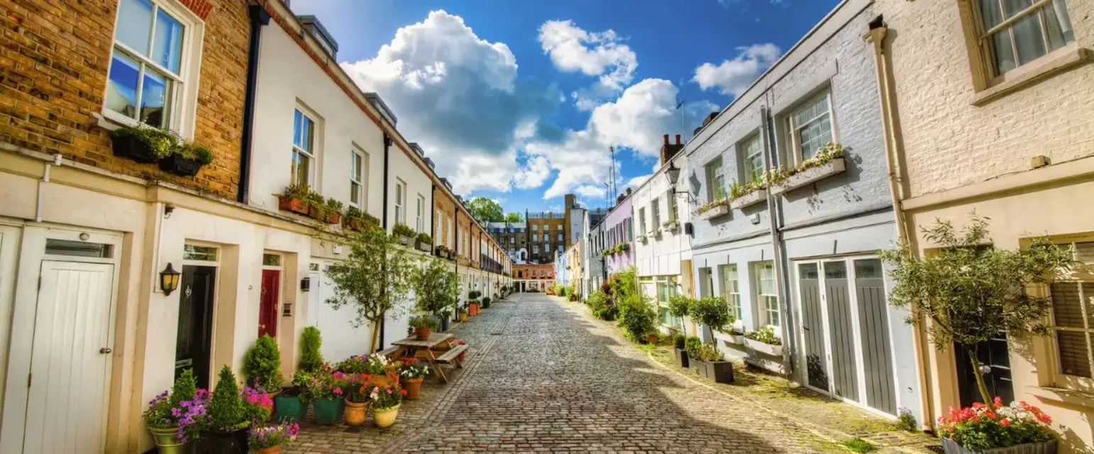 a street with brick buildings and plants on the side