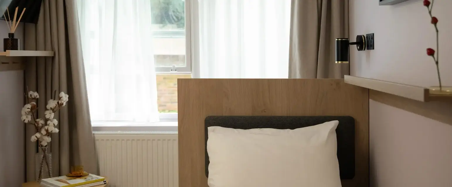 a bed with a pillow and a window