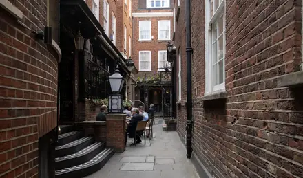 a group of people sitting at tables in a courtyard