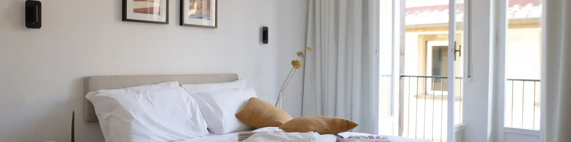 a bed with pillows and a blanket in a room with a balcony