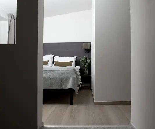 a bedroom with a bed and a plant