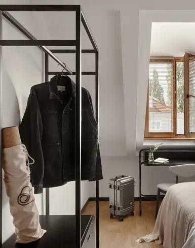 a room with a bed and a coat on a rack