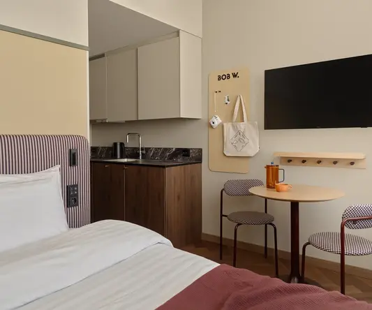 a room with a bed and a table and a tv