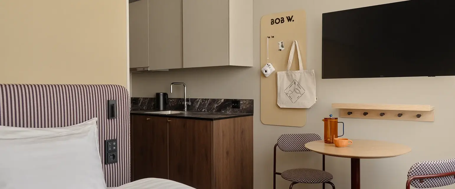 a room with a bed and a table and a tv