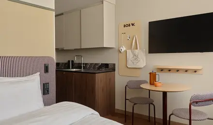 a room with a bed and a table and a tv
