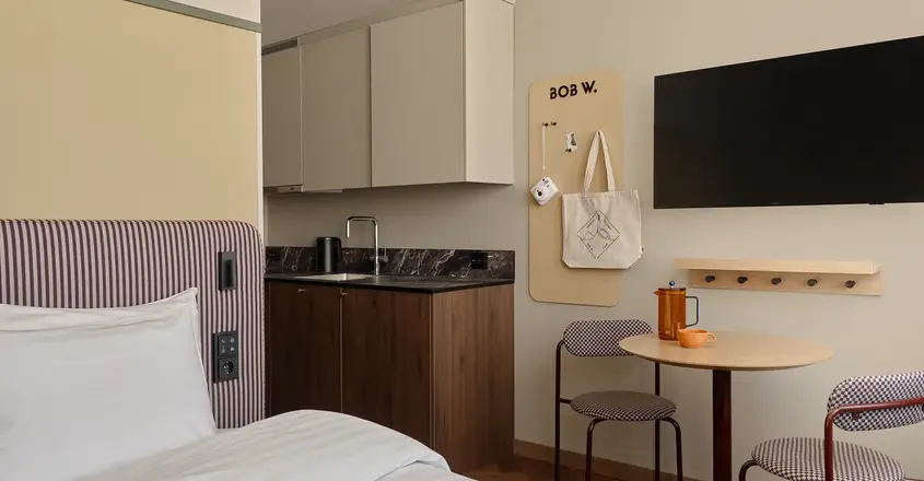 a room with a bed and a table and a tv