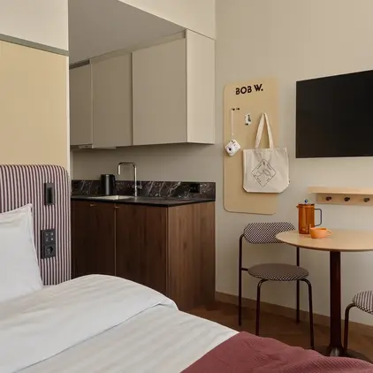 a room with a bed and a table and a tv