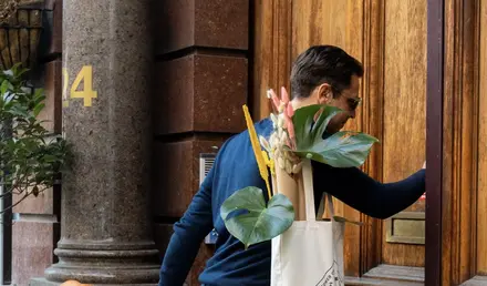 a man walking down a building with a suitcase and a bag