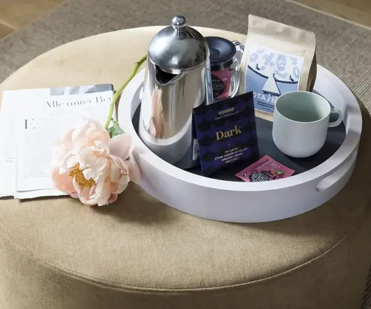 a coffee pot and a flower on a round table
