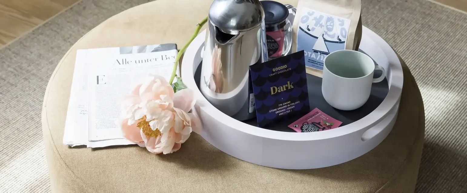 a coffee pot and a flower on a round table