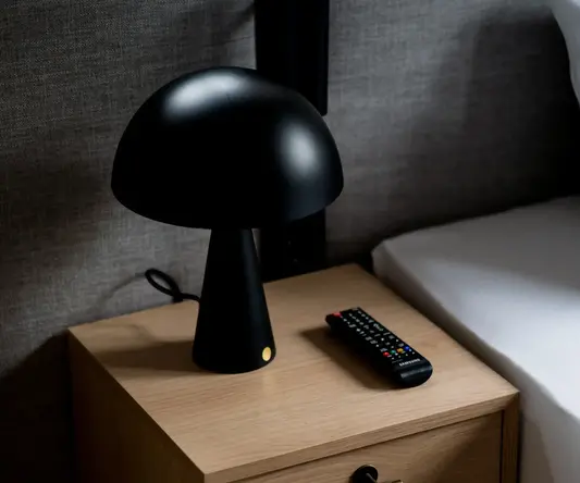 a black lamp on a nightstand