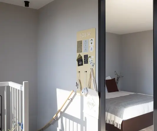 a bedroom with a bed and a board on the wall
