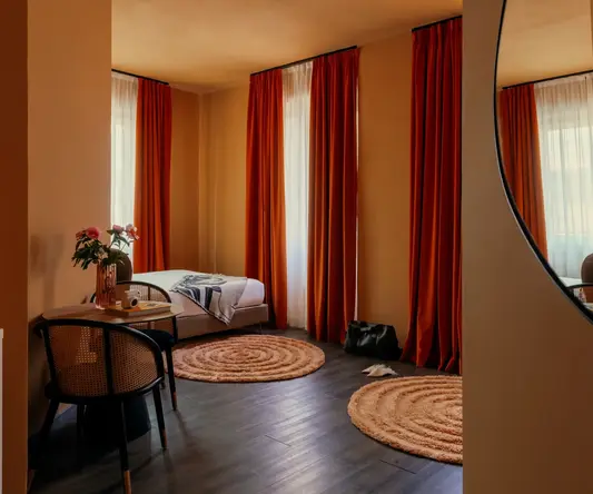 a room with a bed and chairs and a round rug