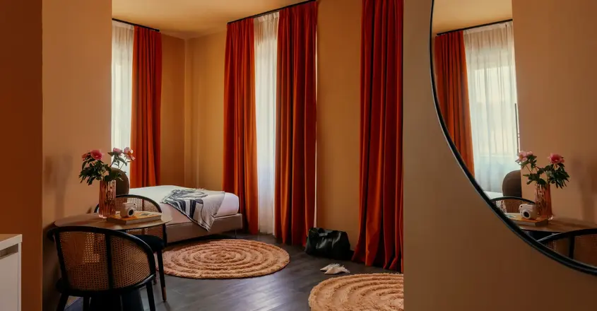 a room with a bed and chairs and a round rug