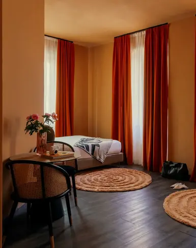 a room with a bed and chairs and a round rug