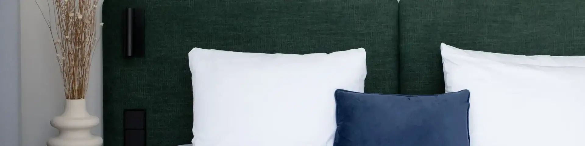 a bed with white sheets and pillows