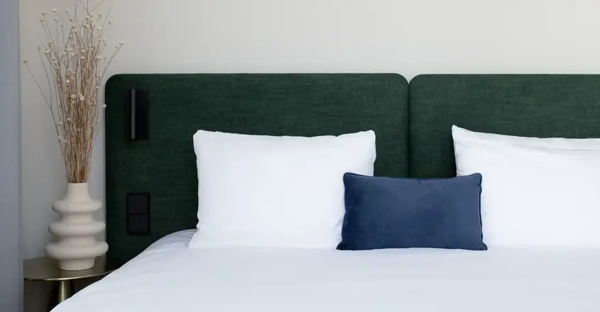 a bed with white sheets and pillows