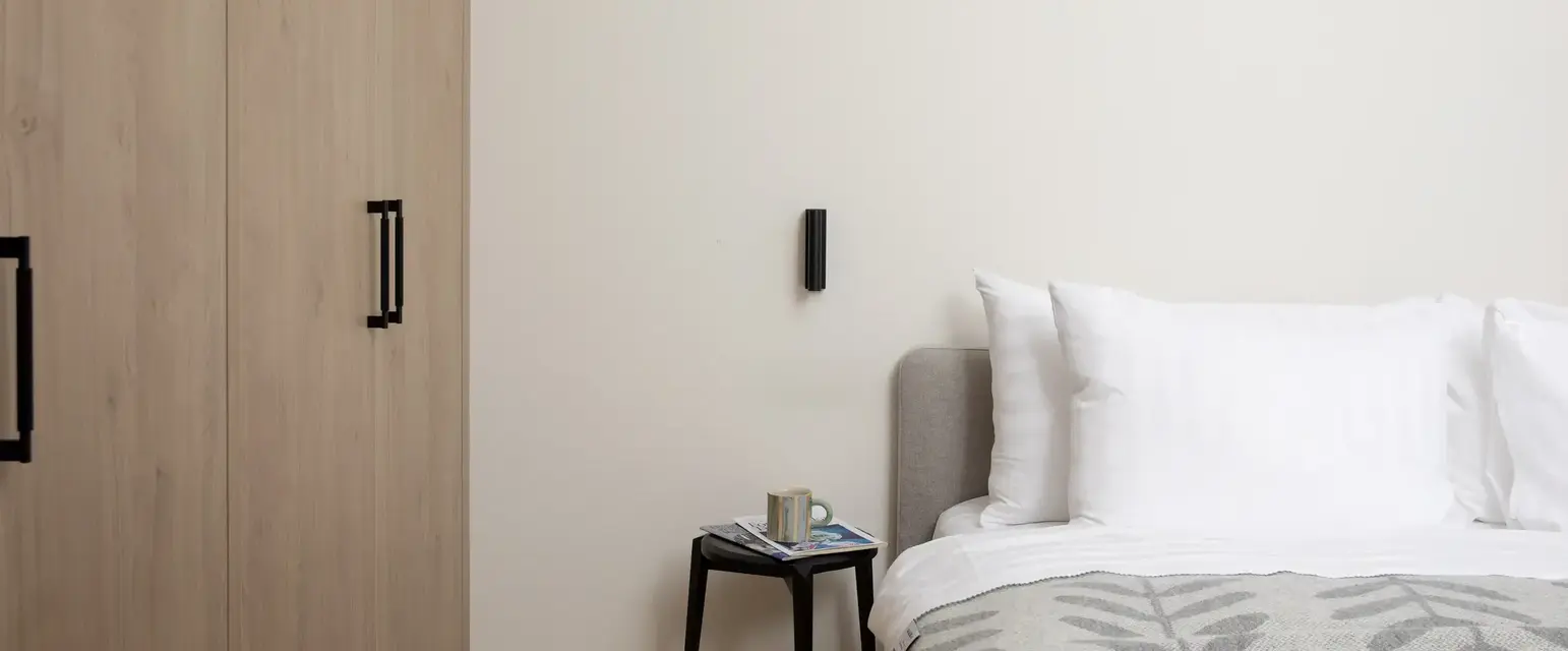 a bed with pillows and a small table