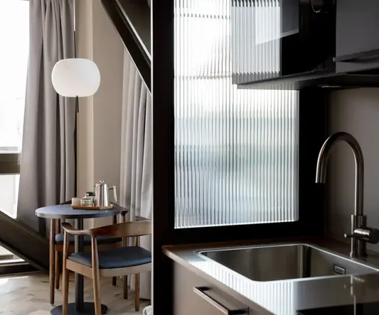 a kitchen with a sink and chairs