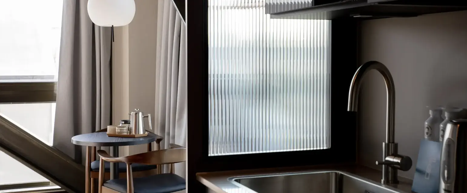 a kitchen with a sink and chairs