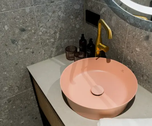 a sink with a faucet and a gold faucet