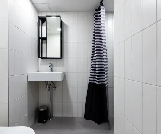 a bathroom with a striped shower curtain and sink