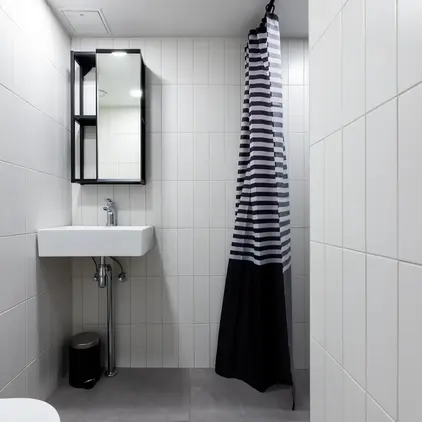 a bathroom with a striped shower curtain and sink