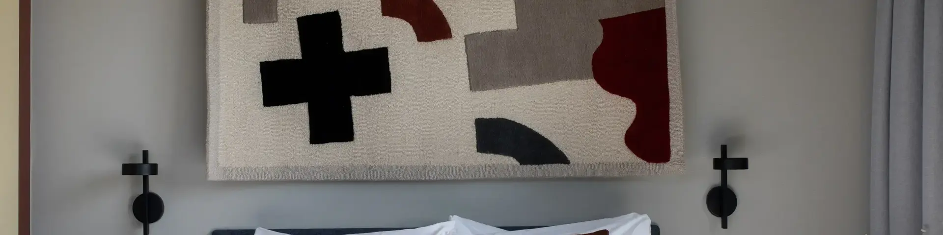 a bed with pillows and a rug above it