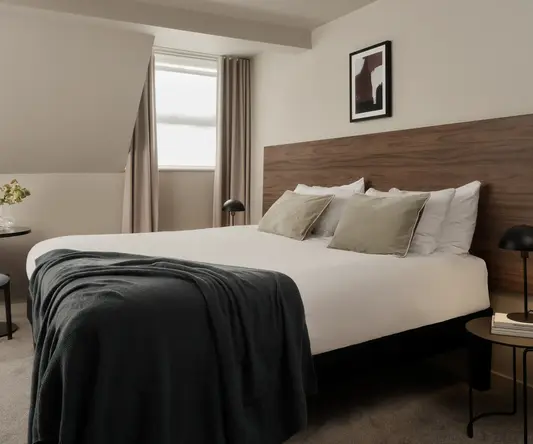 a bed with a black blanket and a wood headboard