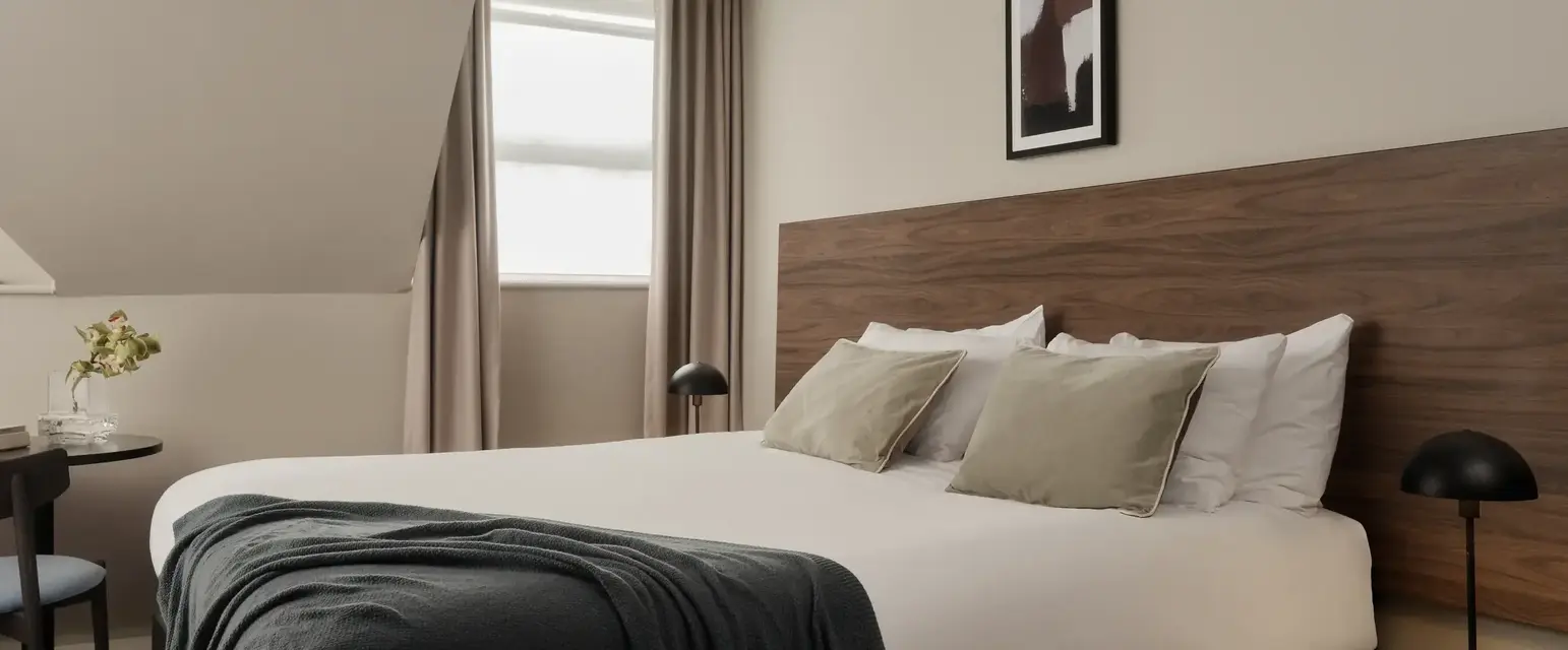 a bed with a black blanket and a wood headboard